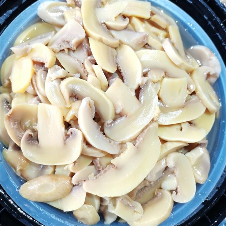 Sliced white mushroom in salt in drums